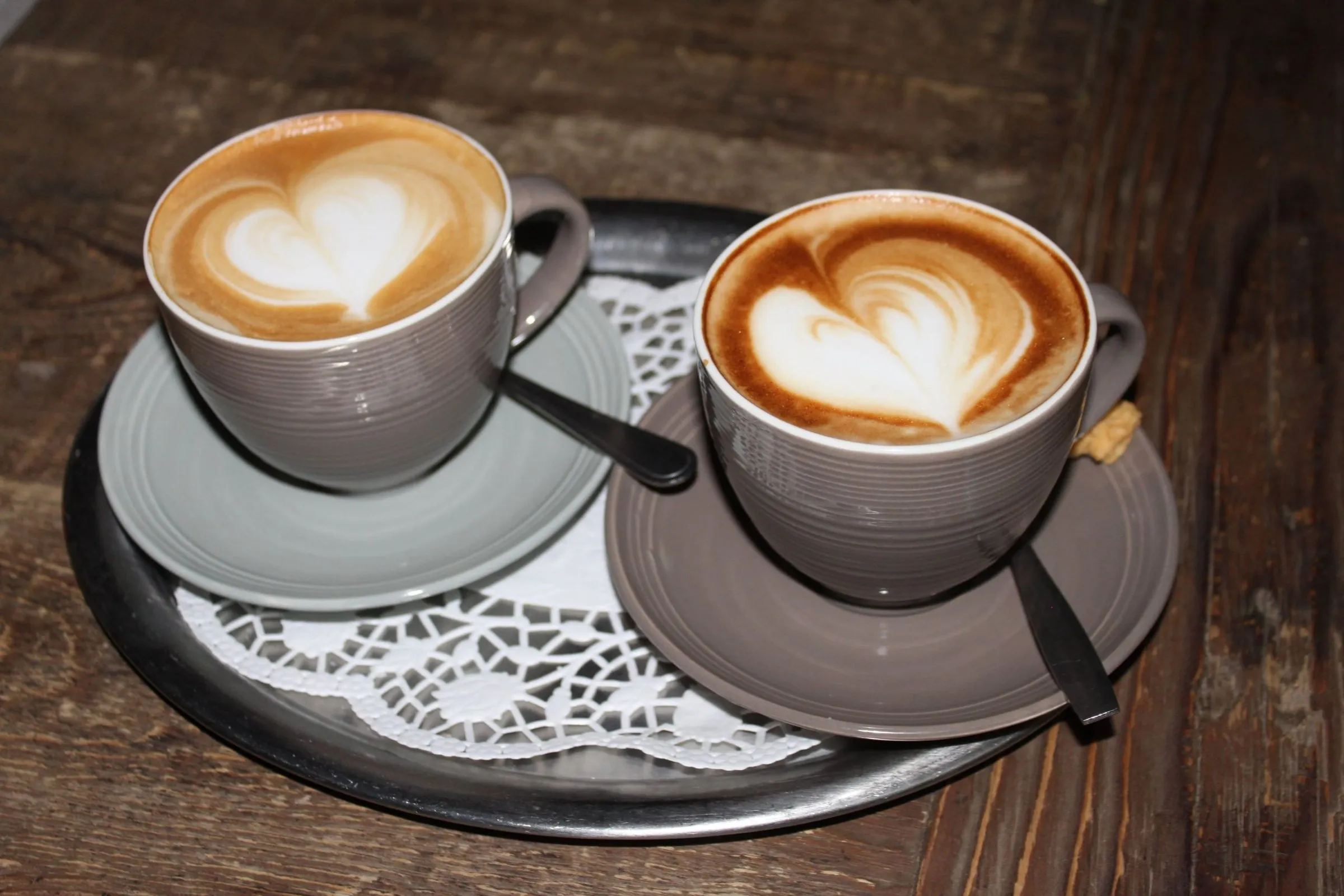 Zwei Cappuccino mit Herz-Latte-Art auf einem Silbertablett